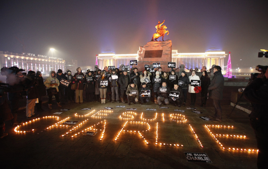 Mongolian journalists holding cards pose next to candles which were placed to form the phrase "I am Charlie" as they pay tribute to the victims of a shooting by gunmen at the offices of French weekly newspaper Charlie Hebdo in Paris, during a candlelight vigil at Genghis Square, formerly Sukhbaatar Square, in Ulan Bator January 9, 2015. Picture taken January 9, 2015. REUTERS/B. Rentsendorj (MONGOLIA - Tags: CIVIL UNREST CRIME LAW MEDIA TPX IMAGES OF THE DAY) - RTR4KVEF